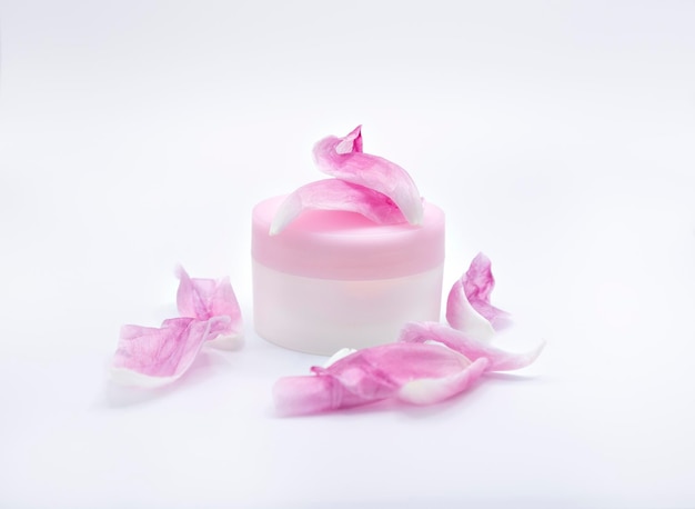 Une petite bouteille de savon avec une fleur rose dessus.