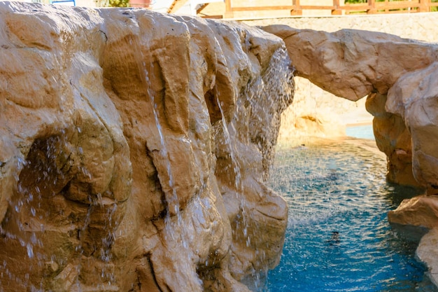 Petite cascade aux eaux turquoises dans la piscine de l'hôtel