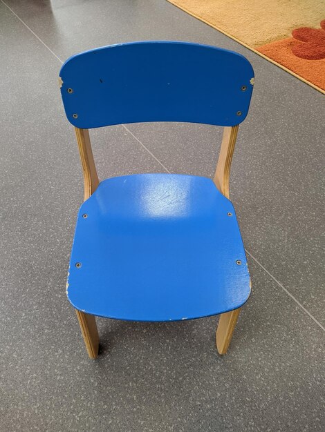 Une petite chaise bleue en bois pour enfants avec un dos