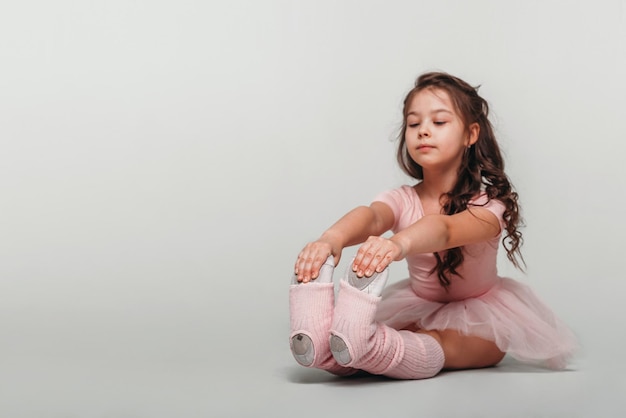 Photo petite danseuse de ballerine dans un étudiant de l'académie de tutu rose posant sur fond blanc