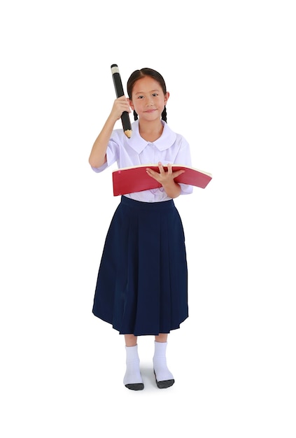 Petite écolière asiatique en uniforme scolaire thaïlandais se tenir debout et tenir un livre avec un gros crayon sur blanc
