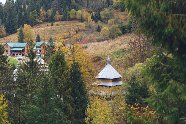 Petite église en bois parmi le feuillage des arbres dans la vallée de montagne