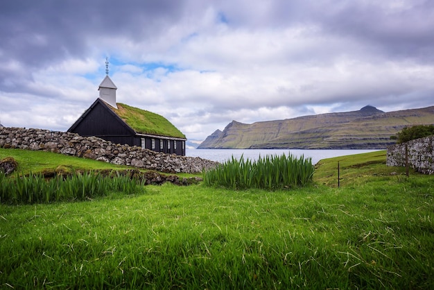 Petite église de village en bois au bord de la mer dans les îles Féroé Danemark