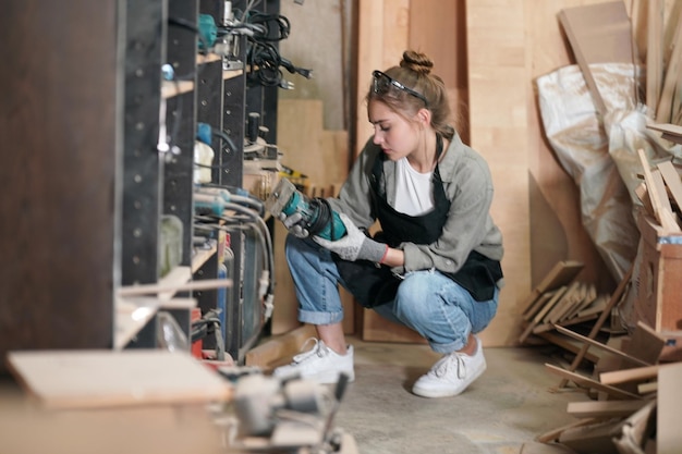 Petite entreprise d'une jeune femme Belle jeune femme ouvrière dans un atelier de meubles mesurant le bois