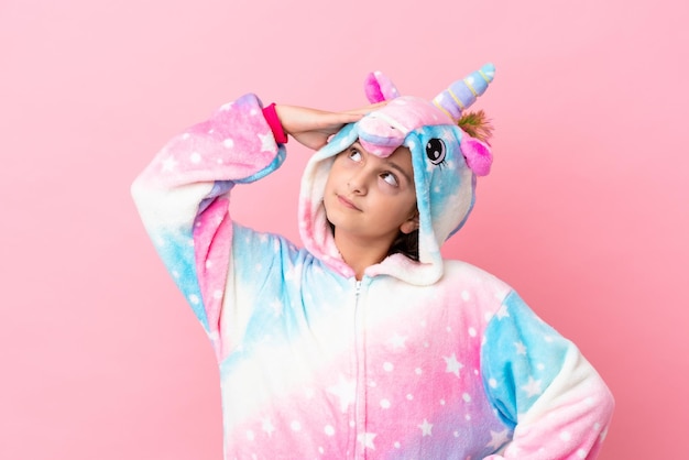 Petite femme caucasienne portant un pyjama licorne isolé sur fond rose souriant beaucoup