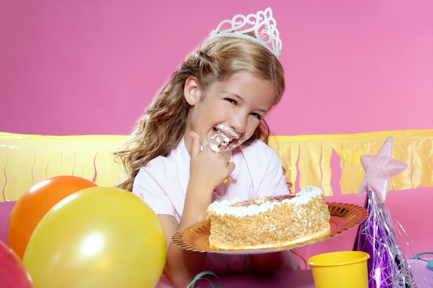 Petite fête d&#39;anniversaire blonde gâteau girleating avec les mains