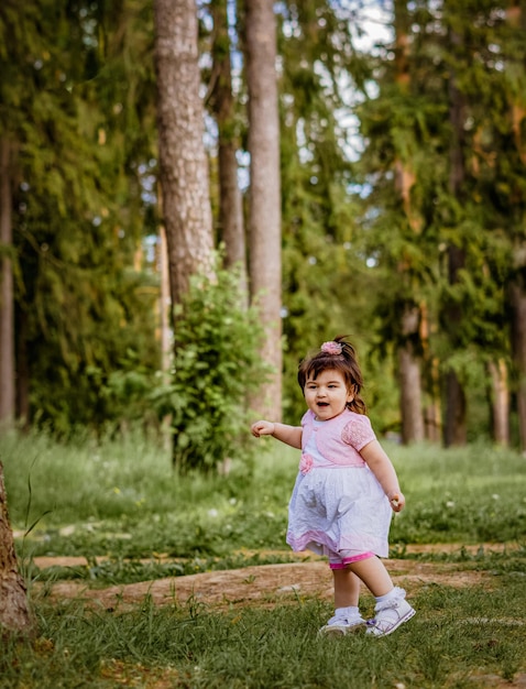 petite fille de 2 ans dans un parc près d'une forêt