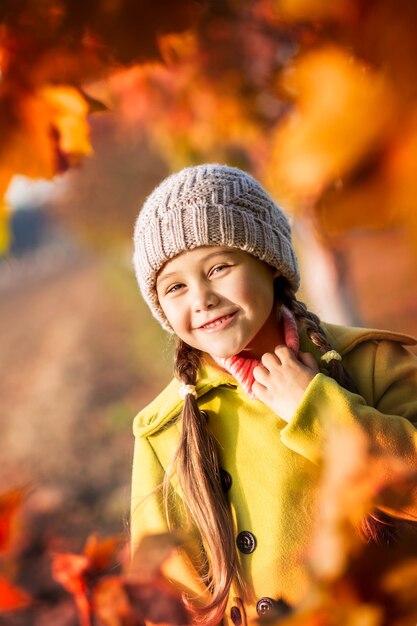 Petite fille de 5 ans avec des feuilles d'érable d'automne rit