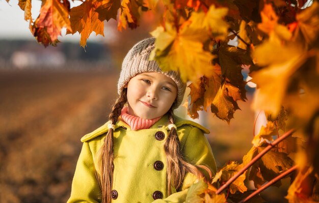 Petite fille de 5 ans avec des feuilles d'érable d'automne