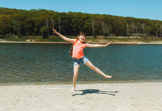 Petite fille de 7 ans s'amuse sur la plage de la ville