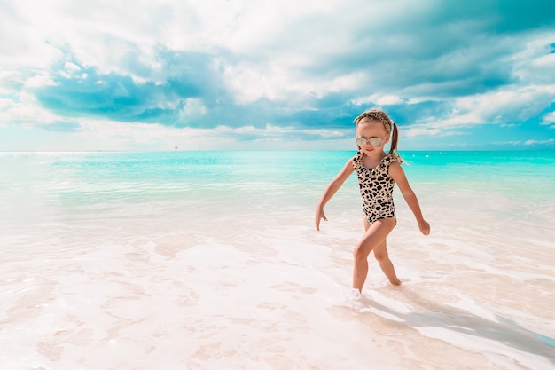 Petite fille active à la plage s'amusant beaucoup.