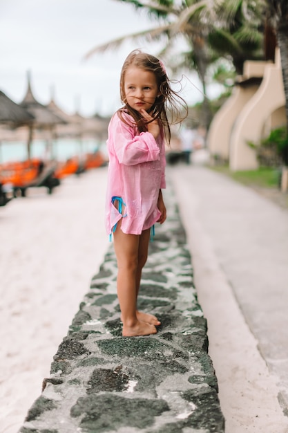 Petite fille active à la plage s'amusant beaucoup.