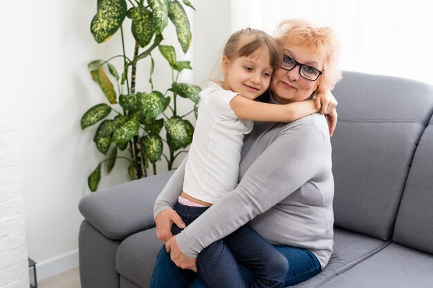 Petite-fille adolescente rendant visite à sa grand-mère à la maison.