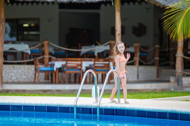 Petite fille adorable heureuse dans la piscine extérieure