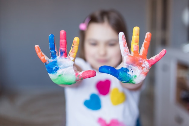 Petite fille adorable joyeuse mignonne joyeuse dessinant seule à la maison pendant les vacances ou la quarantaine. Activité à la maison chez l'enfant, art pour les enfants