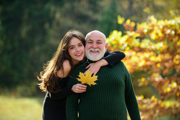 Petite-fille adulte avec un grand-père âgé le serre dans ses bras en parlant debout à l'extérieur