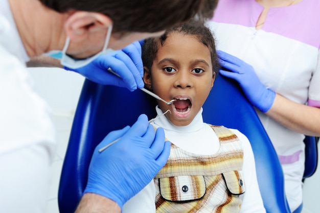 Photo petite fille africaine à la peau foncée en dentisterie