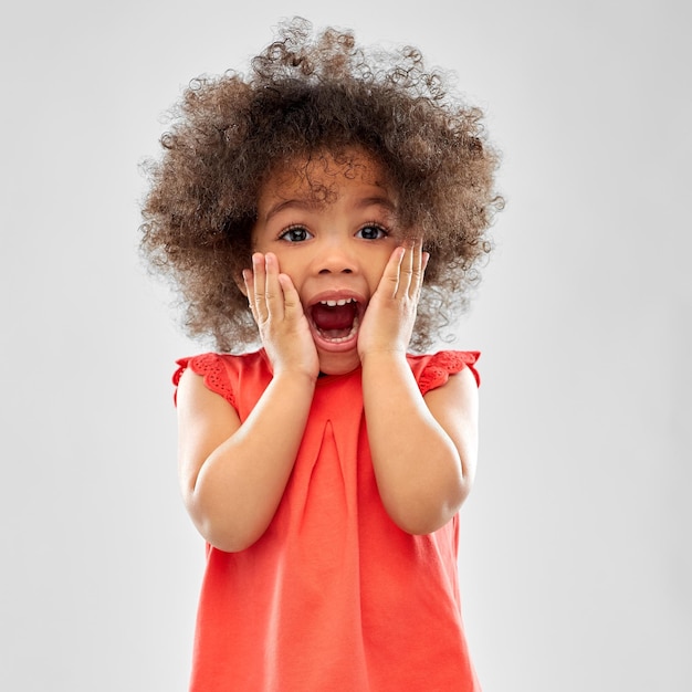 Une petite fille afro-américaine surprise ou effrayée.