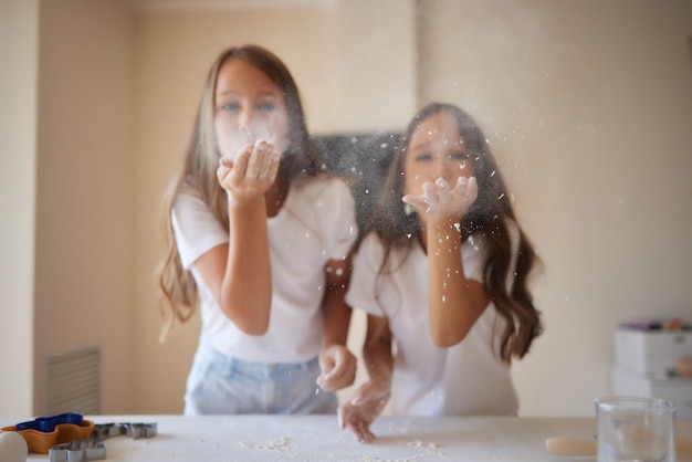 Une petite fille aide à cuisiner dans une cuisine en désordre