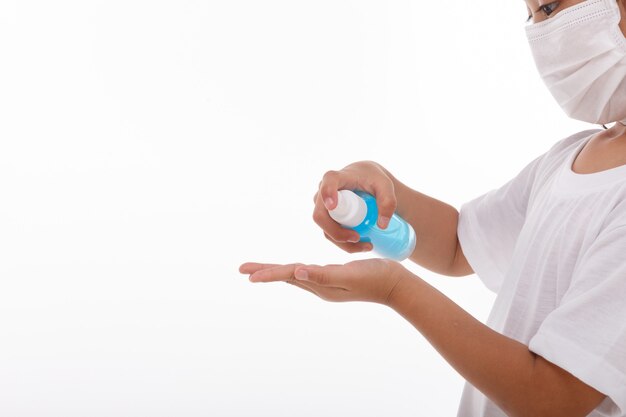 Petite fille à l'aide de gel d'alcool pour se laver les mains.