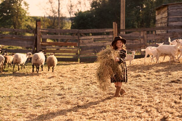 Une petite fille aime être dans une ferme avec des animaux.