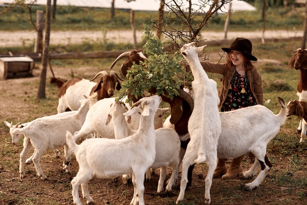 Une petite fille aime être dans une ferme avec des animaux.