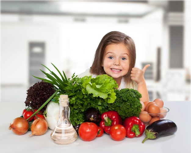 Petite fille avec des aliments sains montrant le pouce vers le haut