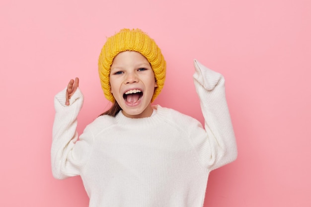 Petite fille amusante dans un chapeau jaune amusant fond isolé