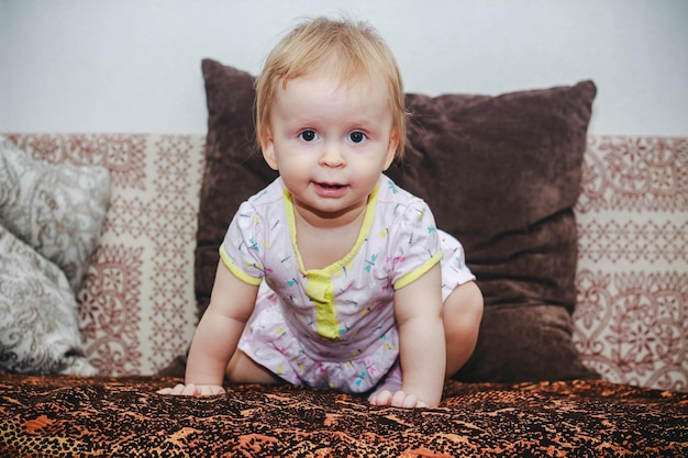 Petite fille d'un an assise sur le canapé