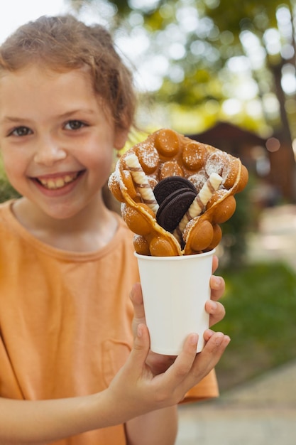 La petite fille apprécie une gaufre belge