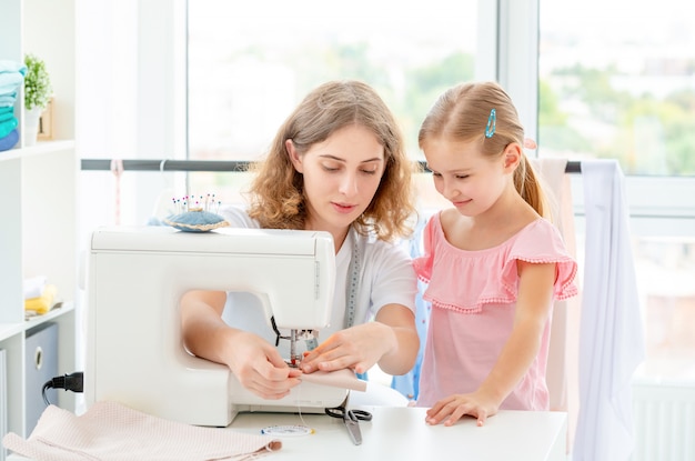 Petite fille apprend à coudre