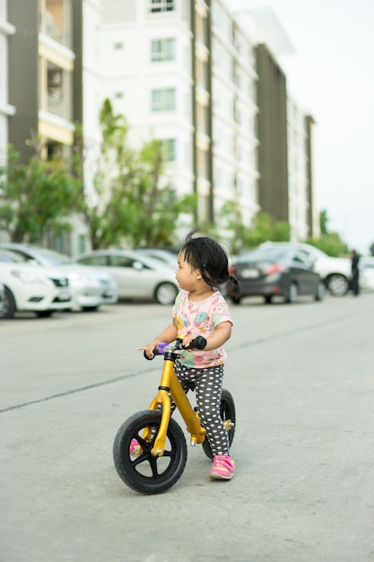 Petite fille apprend à faire du vélo d&#39;équilibre sur la route