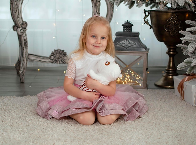 Petite fille à l'arbre de Noël dans la chambre célébrant Noël, nouvel an.