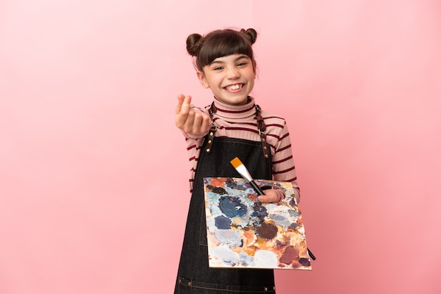 Petite fille artiste tenant une palette isolée faisant le geste de l'argent