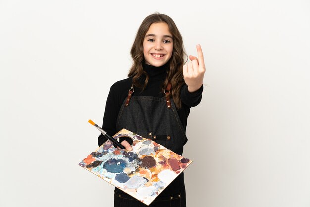 Petite fille artiste tenant une palette isolée sur fond blanc faisant le geste à venir
