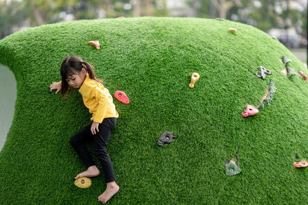 Petite fille asiatique aime jouer dans une aire de jeux pour enfants Portrait en plein air