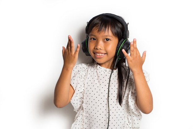 Photo petite fille asiatique, appréciant la musique. danser et bouger exprimant de vraies émotions positives