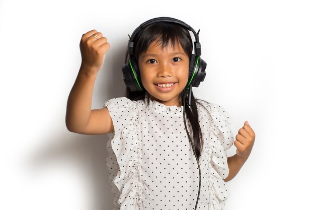 Petite fille asiatique, appréciant la musique. danser et bouger exprimant de vraies émotions positives