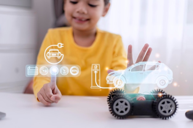 Petite fille asiatique apprenant le système de voiture électrique Concept d'énergie alternative écologique