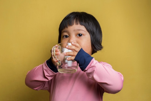 Petite Fille Asiatique Buvant De L'eau En Verre