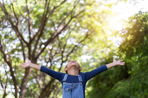 Petite fille asiatique debout et ouvre ses bras dans le jardin, concept d'idée de liberté