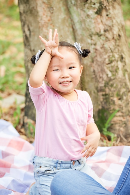 Petite fille asiatique disant au revoir