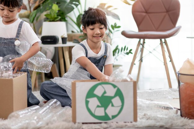 La petite fille asiatique est une poubelle séparée à recycler