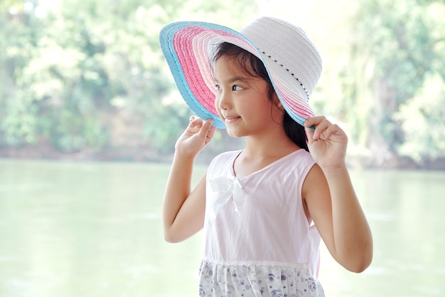 Petite fille asiatique à l&#39;extérieur en chapeau d&#39;été