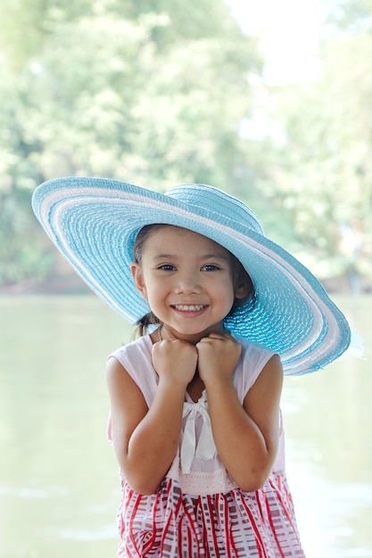 Petite fille asiatique à l&#39;extérieur en chapeau d&#39;été