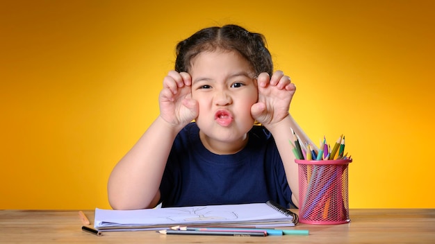 Une petite fille asiatique heureuse qui étudie la classe d'apprentissage en ligne et pose comme un tigre pour le nouvel an 2022. Concept d'apprentissage en ligne ou d'enseignement à domicile. Nouvel an 2022