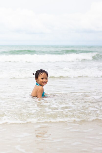 Petite fille asiatique imitant sur le rivage