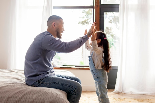 petite fille asiatique joue avec le père mains et paumes enfant coréen haut cinq au père à la maison