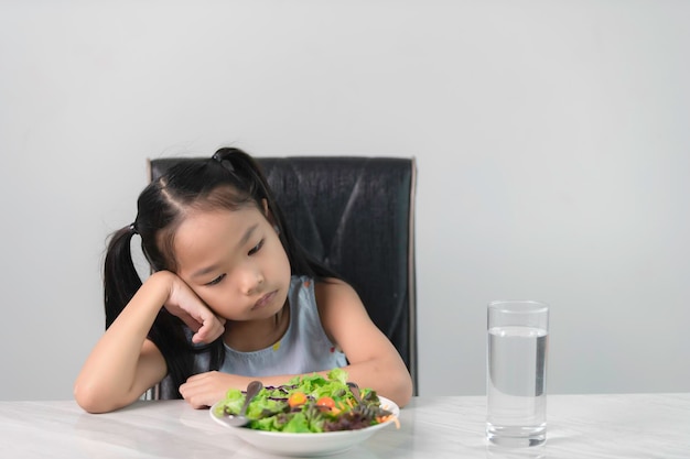 Une petite fille asiatique mignonne refuse de manger des légumes sains Nutrition habitudes alimentaires saines pour les enfants conceptLes enfants n'aiment pas manger de légumes