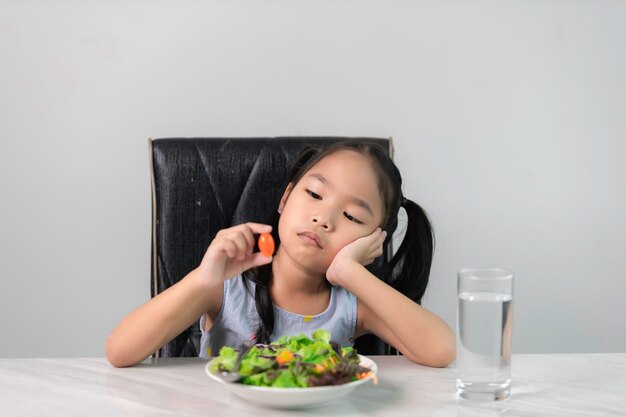 Une petite fille asiatique mignonne refuse de manger des légumes sains Nutrition habitudes alimentaires saines pour les enfants conceptLes enfants n'aiment pas manger de légumes